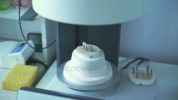 Close-up de um dente de fogo coroas em um forno automático em laboratório 4K — Vídeo de Stock