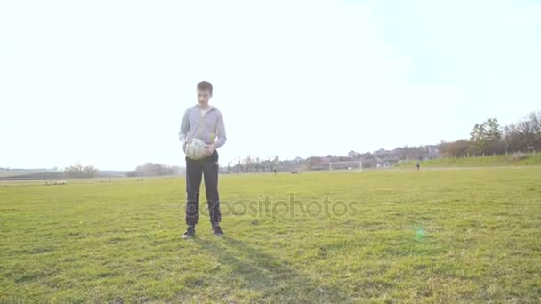 Wesoły chłopak, rzucanie się piłkę na stadionie w 4k — Wideo stockowe