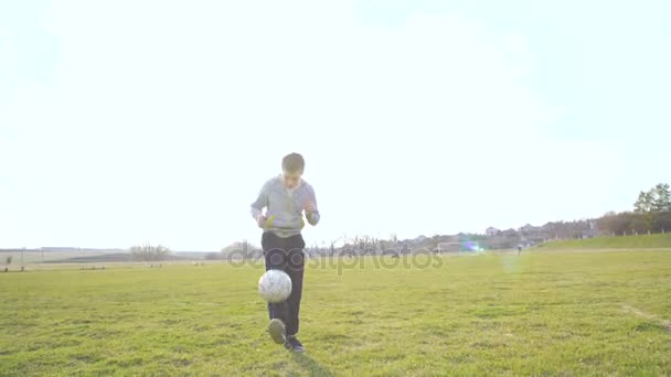 Веселый мальчик бросает мяч на стадион в 4K — стоковое видео