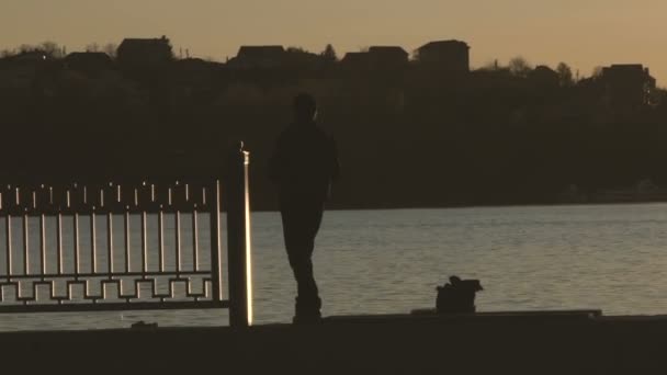 Silhouette of a fisherman on the sunsets nature background — Stock Video