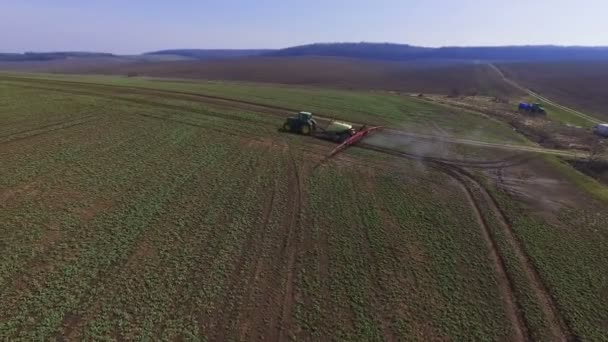 Luchtfoto beelden van trekker besprenkelt het koolzaad veld met chemicaliën in 4k — Stockvideo
