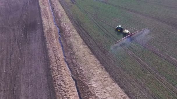 Imágenes aéreas del tractor rociando los campos de colza con productos químicos en 4K — Vídeo de stock