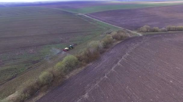 Aerial footage av traktor strössel raps fält med kemikalier i 4k — Stockvideo