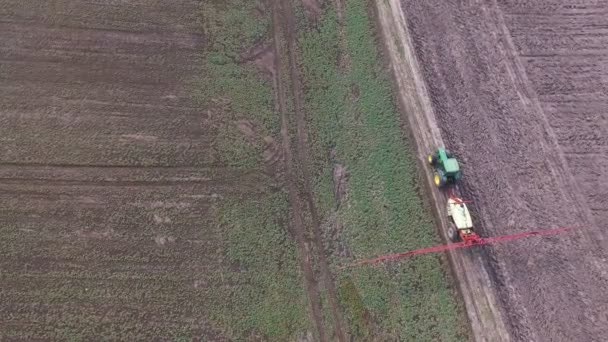 Des images aériennes du tracteur saupoudrent les champs de colza avec des produits chimiques en 4K — Video