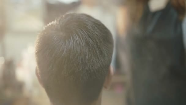 Bonito homem com sorriso no rosto recebe um corte de cabelo no salão — Vídeo de Stock