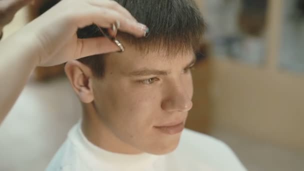 Bel homme avec sourire sur le visage obtient une coupe de cheveux dans le salon — Video