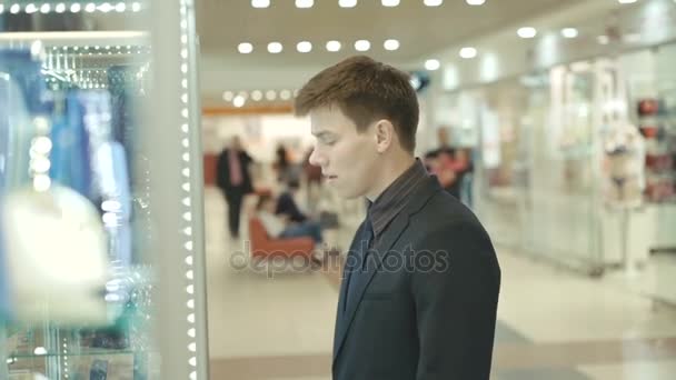 Bello uomo in abito orologi e dubbi nell'acquisto di borsa ricca — Video Stock