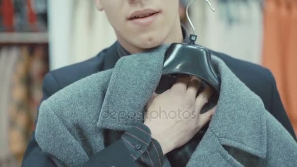 Elegant ung man i kostym passande kappa i klädaffär — Stockvideo