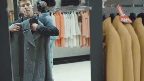 Jeune homme élégant en costume manteau dans le magasin de vêtements — Video