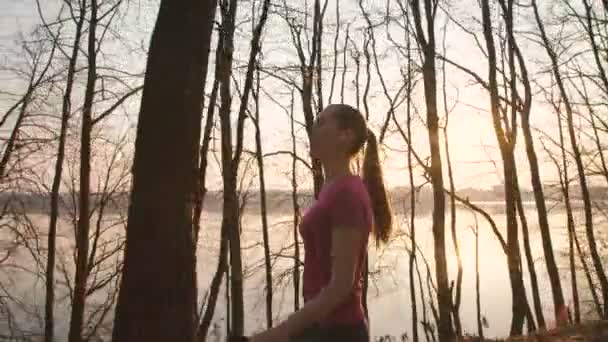 Mooi meisje lopen in het park en luisteren naar de muziek in oortelefoons 4k — Stockvideo