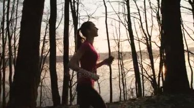 Güzel kız parkta koşmak başlar ve kulaklık 4 k müzik dinlemek