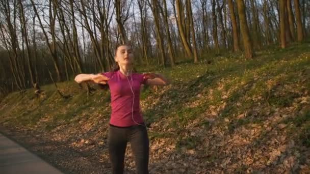 A menina treina alongando-se na natureza no parque 4K — Vídeo de Stock