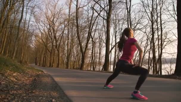 De tjej träning stretching på naturen i parken 4k — Stockvideo