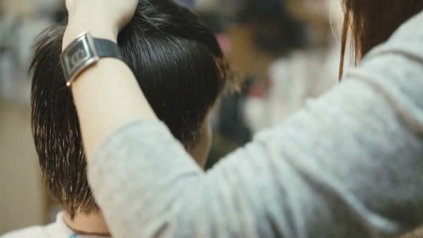 Beau jeune homme obtient une coupe de cheveux dans le salon 4K — Video