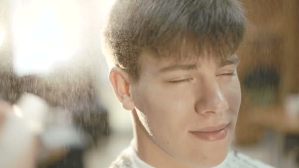 Hombre guapo con sonrisa consigue un pelo rociando en el salón 4K — Vídeos de Stock