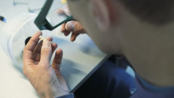 Closeup de dentes de moagem coroas com instrumentos em laboratório odontológico em 4K — Vídeo de Stock