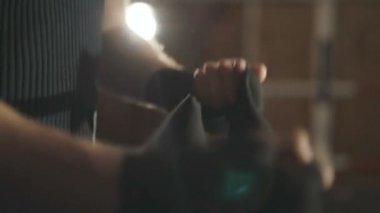 Spor salonunda halkası üzerinde siyah bandaj ile elleri erkek boxer sarar