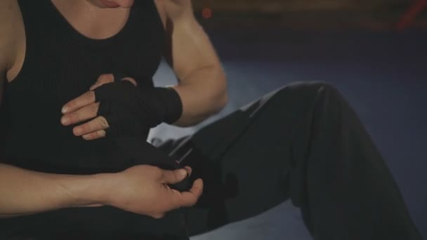 Pes boxer zalomí rukama s černými obvaz na kroužku v tělocvičně — Stock video