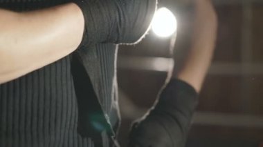 Erkek boxer salonunda yüzükteki elleri siyah bandaj ile tamamladı. Yavaş yavaş