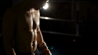 Yakışıklı kickboxers ışıkları ile karanlıkta halkada savaşır. Yavaş yavaş