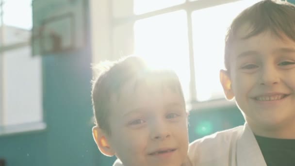 Sarılma, surat ve kamera jimnastik salonu için gülüyor iki komik yontma çocuğu — Stok video