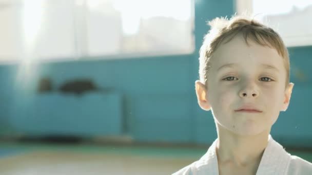 Bonito menino cansado olhando e sorrindo para a câmera no ginásio 4K — Vídeo de Stock