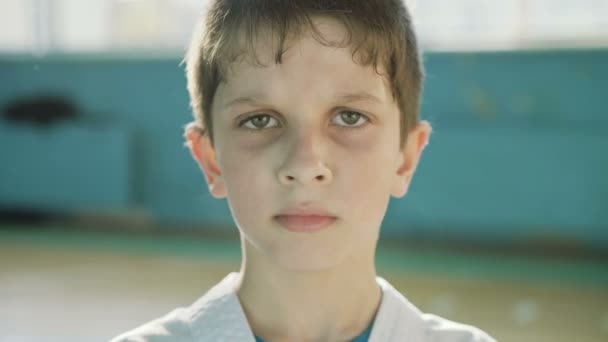 Schöner junger Junge schaut ernsthaft in die Kamera in der Turnhalle 4k — Stockvideo