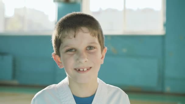 Stilig ung pojke tittar och uppriktigt leende på kameran i gymmet 4k — Stockvideo