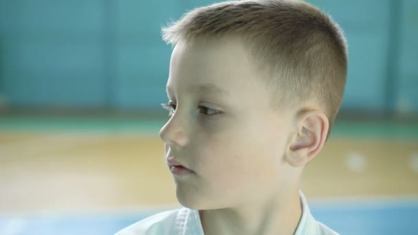 Frumos băiat cu ochi mari care se uită și zâmbesc sincer la camera de gimnastică 4K — Videoclip de stoc