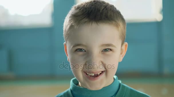 Chico divertido con dientes astillados riendo a la cámara en el gimnasio 4K — Vídeos de Stock