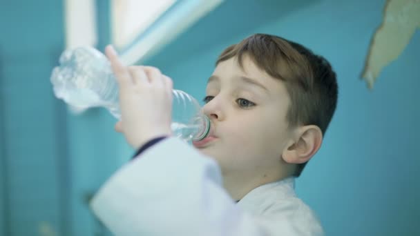 Weinig sportman drinkt een water- en grappig lachen om de camera in de sportschool 4k — Stockvideo