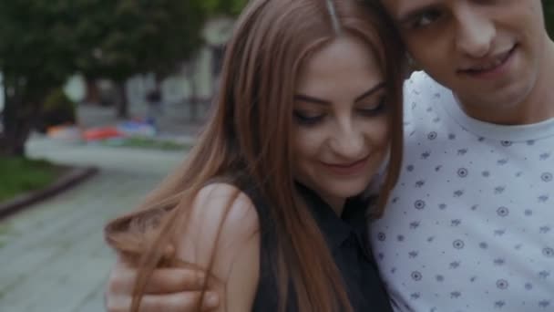 Щаслива пара закохалася, гуляючи по вулиці, посміхаючись і обіймаючи один одного — стокове відео