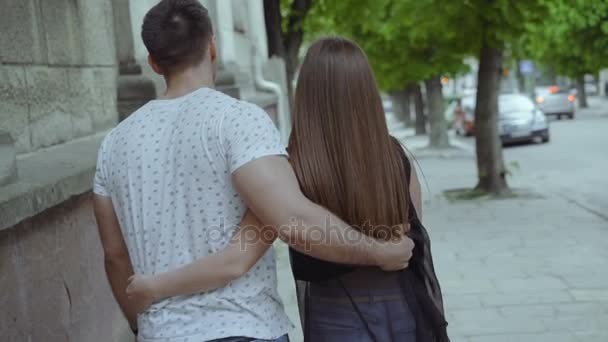 Back-Look eines verliebten Paares geht auf der Straße und umarmt. langsam — Stockvideo