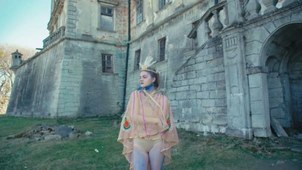 Девушка в образе горошины позирует возле древнего замка 4K — стоковое видео