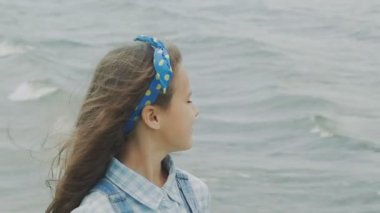 Küçük esmer gülümseyen ve sahil kameraya bakarak havuz kenarında. Yavaş yavaş