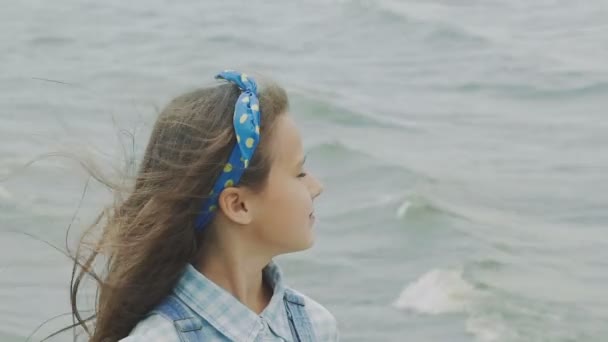 Pequeña morena cerca de la piscina sonriendo y mirando a la cámara en la costa. Despacio. — Vídeos de Stock