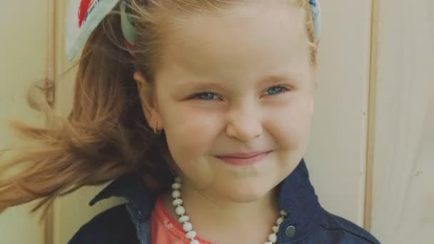 Πορτραίτο του κοριτσάκι με το φύσηγμα μαλλιά χαμογελώντας σε εσωτερική κάμερα. Σιγά-σιγά — Αρχείο Βίντεο