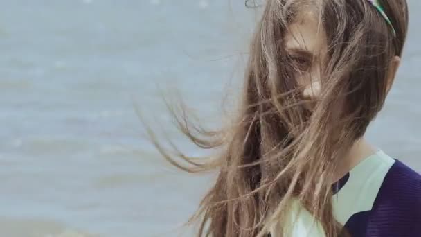 Retrato de uma menina com cabelo ondulado olhando para a câmera no fundo da piscina. Devagar. — Vídeo de Stock