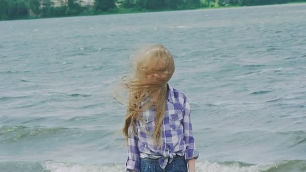 Гламурная и стильная блондинка позирует перед камерой на побережье. Медленно. — стоковое видео