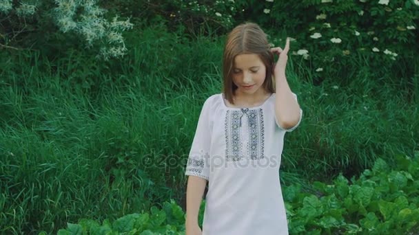Mooie jonge meisje poseren en raakt haar haren op planten achtergrond. Langzaam — Stockvideo
