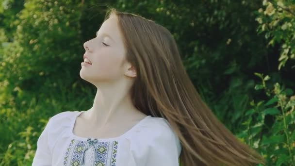 漂亮的年轻女孩在植物背景上摆着她的头发慢慢 — 图库视频影像