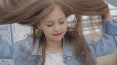 Kamera 4k için gülümseme ile doğru uzun saçlı akıllı küçük kadın modeli