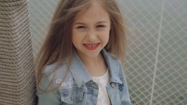 Modelo feminino pequeno inteligente com cabelo longo sorrindo e olhando para a câmera 4K — Vídeo de Stock