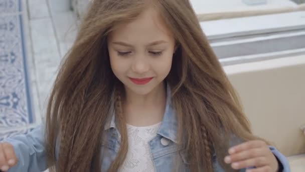 Slimme kleine vrouwelijke model met juiste lange haren met glimlach voor camera 4k — Stockvideo