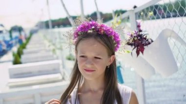 Cute young girl smiling at camera on the bay bar. 4K