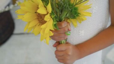 Kızlar el ayçiçeği bir buket 4 k tutmak.