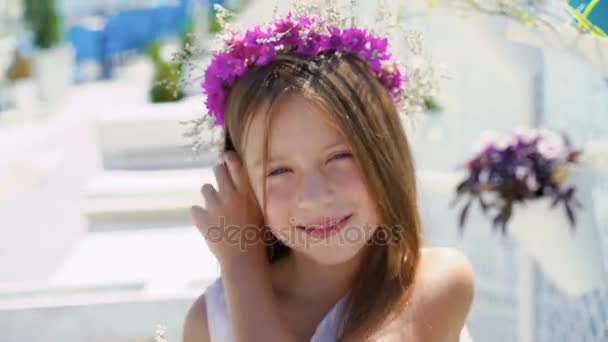 Lycklig liten flicka med blombukett ler mot kameran på bay bar. 4k — Stockvideo