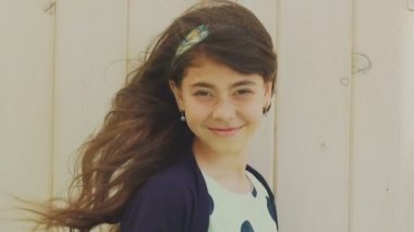 Küçük güzel esmer kahverengi gözleri ve uzun saç kameraya gülümseyen. Yavaş yavaş