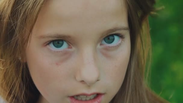 Nahaufnahme Porträt eines jungen lächelnden Mädchens mit blauen Augen, das in die Kamera blickt. langsam — Stockvideo