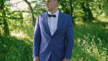 Mutlu damat doğru düğün papyon yeşil ışık ormandaki 4k